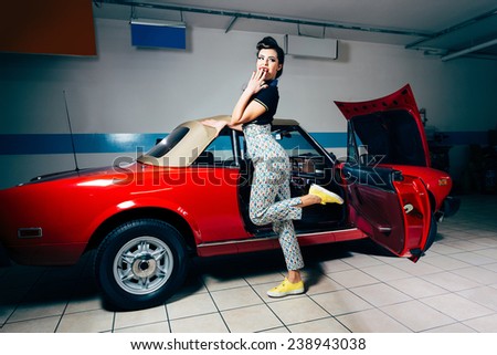 Pretty young woman posing in vintage garage