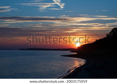 Similar – Image, Stock Photo The sun sets behind a row of leafless trees