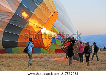 Cappadocia, Turkey - August, 10 2013 :  Ground Crew blasting the burner flame into the balloon envelope to inflate Hot Air Balloon before launching