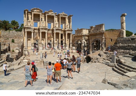 Ephesus, Turkey - August, 7 2013 :  Tourists admiring an ancient Greek and Roman Library structure. It is a popular tourist stop near the city of Izmir in Turkey.