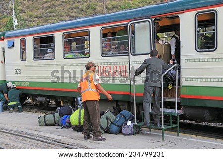 Ollantaytambo Peru - April 23 2014: Train station officers loading tourists luggages into Inca Rail Train to Machu Picchu pueblo before depart from Ollantaytambo station on April 23, 2014 in Peru.