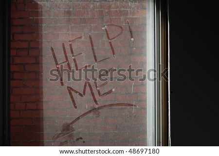 image of the words Help Me written in dust on a lit window