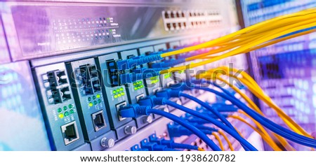 Fiber Optical cables connected to an optic ports and Network cables connected to ethernet ports Imagine de stoc © 