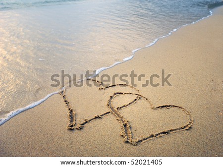 two hearts drawn in beach in sunset