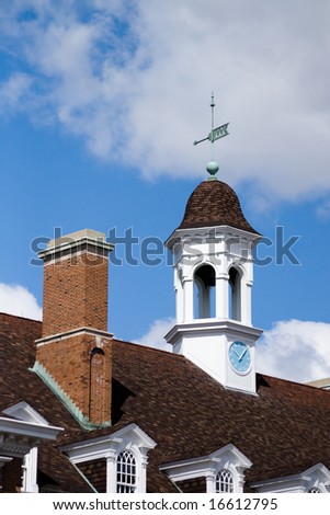 Color photograph of a clock, wind indicator, and chimney on the roof of the University of Illinois Union Building.