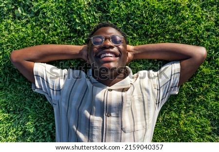 Image, Stock Photo Carefree black man lying on blanket with laptop in park