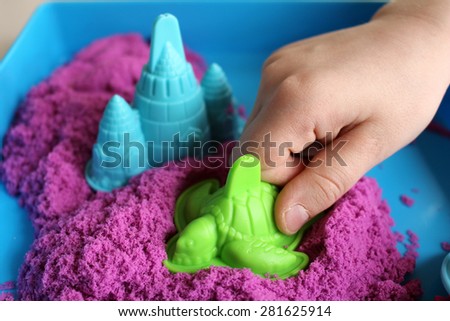 Fun kinetic sand.Child building sandcastle