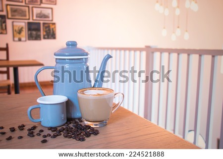 Coffee set, cup, beans,  kettle in coffee shop environment.