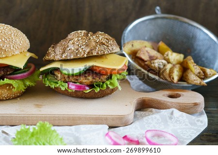 Homemade Chicken Hamburger on White and Brown Bread with Fried Potatoes.