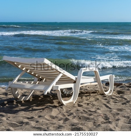 plastic sun lounger at the water's edge on the sandy beach of the Italian town of Lido Ostia, Italy Foto stock © 