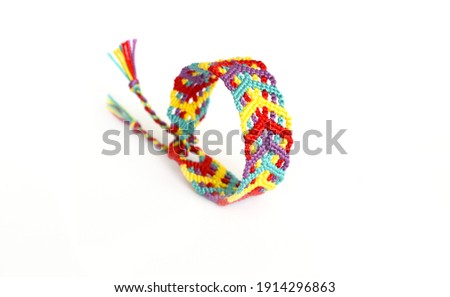 Tied woven friendship bracelet with bright colorful pattern handmade of thread on white background Photo stock © 
