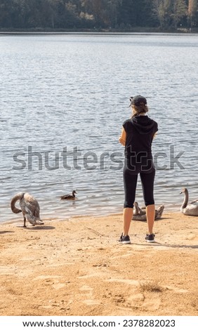 Similar – Foto Bild Junge Frau füttert Schwäne, am Ufer.