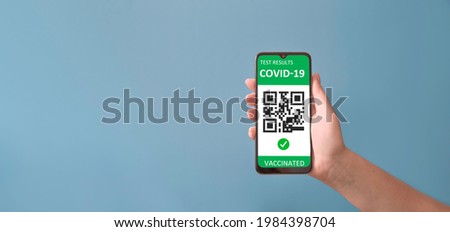 Vaccinated person holding mobile phone with digital health passport for travel during covid-19 pandemic. Green certificate
