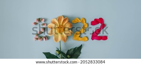 2022 number made from fresh plants, flowers and leaves. Happy New Year concept on blue background. 2022 creative background, card design