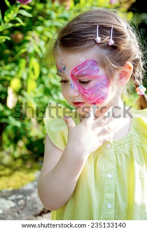 Beautiful girl with painted butterfly on face