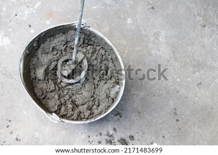 Mixing of concrete mortar.The builder prepares the cement mortar using a construction mixer.Plaster mortar in a bucket. Stockfoto © 