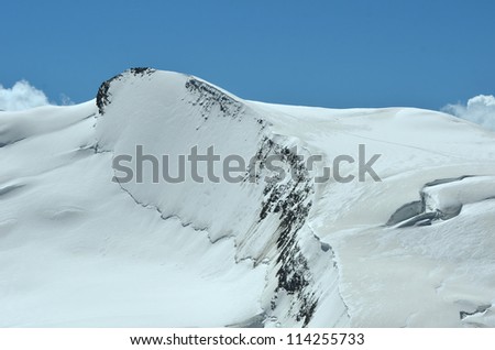 The summit ice capped ridge of the Strahlhorn in the southern swiss alps between Zermatt and Saas Fee