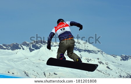 VEYSONNAZ, SWITZERLAND - MARCH 11: Ken VUAGNOUX (FRA) takes to the air in the Snowboard Cross World Cup: March 11, 2014 in Veysonnaz, Switzerland