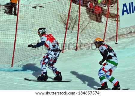 VEYSONNAZ, SWITZERLAND - MARCH 11: OLYUNIN (RUS) leads LEONI (ITA) in the Snowboard Cross World Cup: March 11, 2014 in Veysonnaz, Switzerland