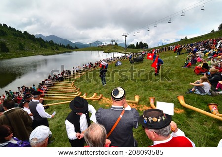 NENDAZ, SWITZERLAND - JULY 27: All contestants together by the lake at the  finals of the 13th International Festival of Alpine horns :  July 27, 2014 in Nendaz Switzerland