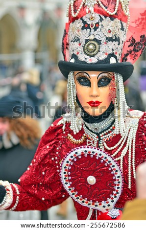 VENICE, ITALY - FEBRUARY 12: Carnival masked costume in red with high hat atthe 2015 Venice Carnival:  February  12, 2015 in Venice, Italy