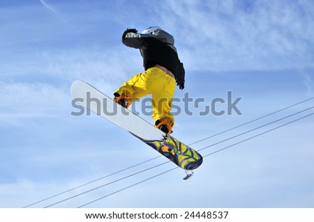 Airoski: a snowboarder in yellow pants hanging in the sky