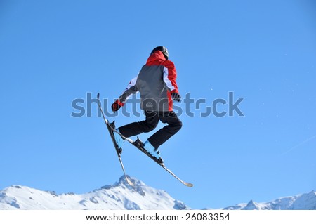 a skier performing a jump without sticks. In his wake flecks of snow