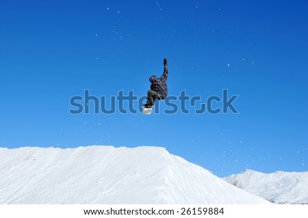 a girl snowboarder takes off from a jump and reaches for the sky with her right arm
