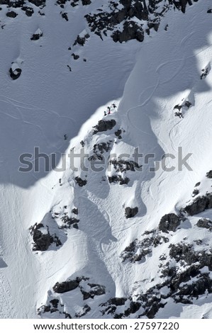 a woman snowboarder in the 2009 womens extreme freeride world championships approaches a ridge with observers and film crew watching