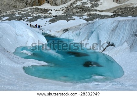 an ice lake resting on a glacier in the spring. This lake grows to fill the hole as the year warms. The glacier is melting faster and faster because of global warming