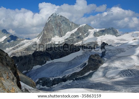 the high summit of the Dent Blanche a challenging peak to climb in Switzerland surrounded by glaciers and blue ice. Viewed from the west.