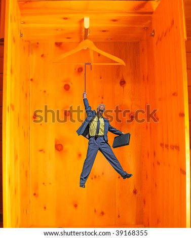 business man with briefcase suspended by a fine line in a wardrobe