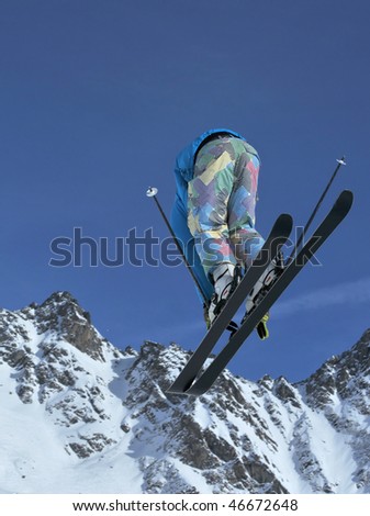 a skier touches his toes during a high jump