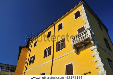 italian renaissance castle with yellow walls and shuttered windows at Duino in Italy
