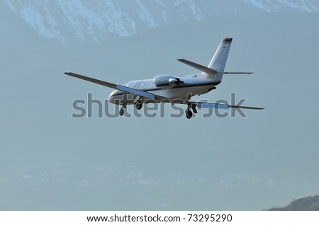 Corporate jet landing with mountains in the background