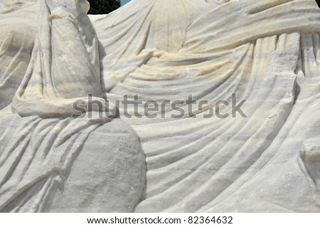 details of beautiful  ancient roman sculpture of flowing togas executed in white marble