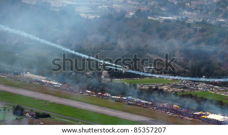 SION, SWITZERLAND - SEPTEMBER 17: Breitling jet team perform a cross over in front of spectators at the Breitling Air show.  September 17, 2011 in Sion, Switzerland