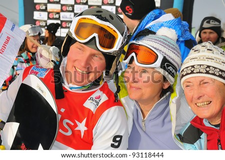 VEYSONNAZ, SWITZERLAND - JANUARY 19: The 2012 FIS World Snowboard Cross Champion A Boldykov (L) of Russia poses for a photo with Russian fans at the snowboard cross finals on January 19, 2012 in Veysonnaz, Switzerland