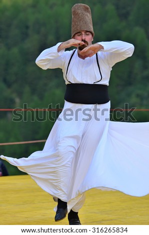 AROLLA, SWITZERLAND - AUGUST 12: Whirling dervish from Bozdaglar in the CIME mountain culture Festival: August 12, 2015 in Arolla, Switzerland