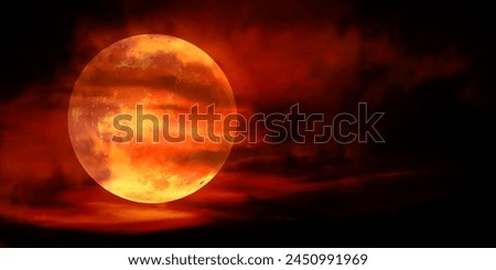 Red Moon, a real full moon in the dark cloudy sky with the moon's red light effect