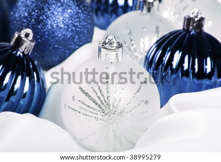 Blue and silver christmas decorations on a white background with space for text