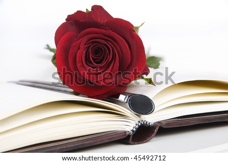Lovely red rose and pen on a classic note book