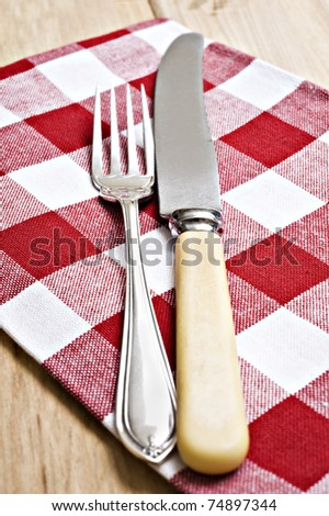 Antique knife and fork on a red and white cloth