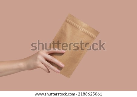 Woman's hands hold cardboard packages for tea or snacks on a beige background. Tea branding and packaging mockup. High quality photo Foto stock © 