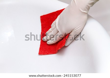 Hand in glove cleans washbasin red sponge