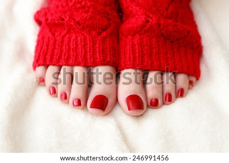 Female feet with a pedicure in red socks