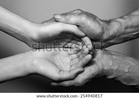 Hands of the old and the young man. Black and white. top view