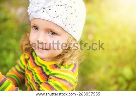 Sweet little girl outdoors with curly hair in the header. soft light