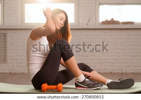 Beautiful sports girl does exercises in the gym. soft light