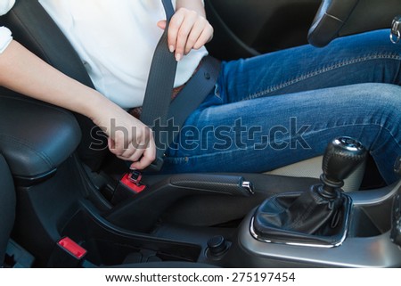 Woman fastens a seat belt. Safe driving concept